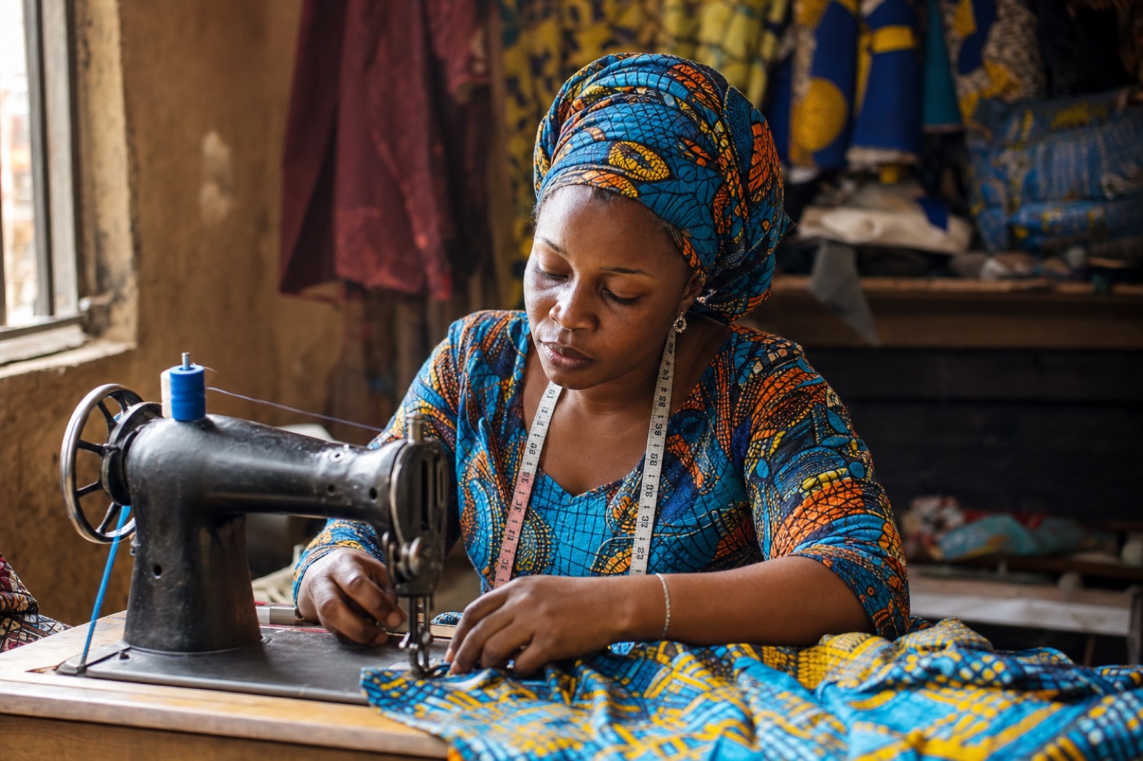 Tailor sewing colourful Ankara fabric at a sewing machine